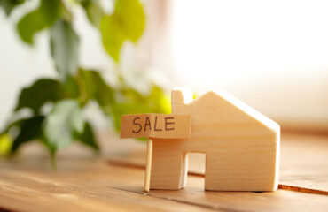 Wooden house model and for sale sign